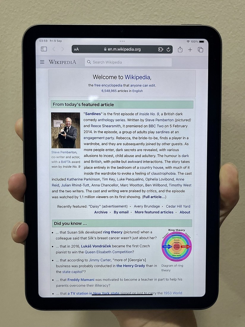 A sixth-generation iPad mini held in a hand. Historical product photograph; it is not the newly announced A20 Pro model.